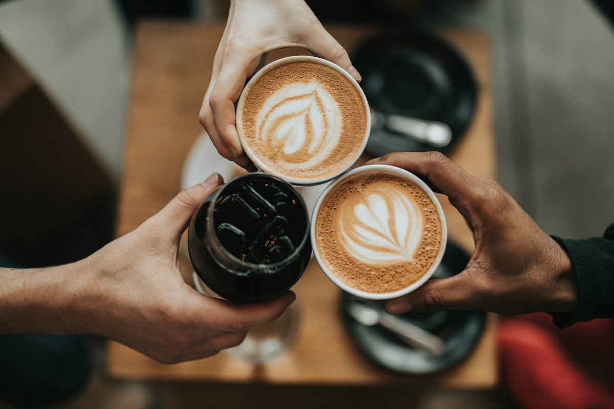 朋友们碰杯的咖啡拉花特写